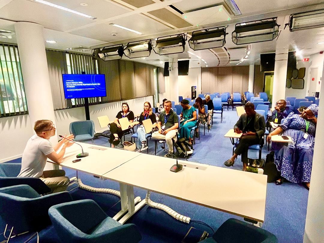 Vitaliy Syzov addressing an international audience seated in a Brussels briefing room