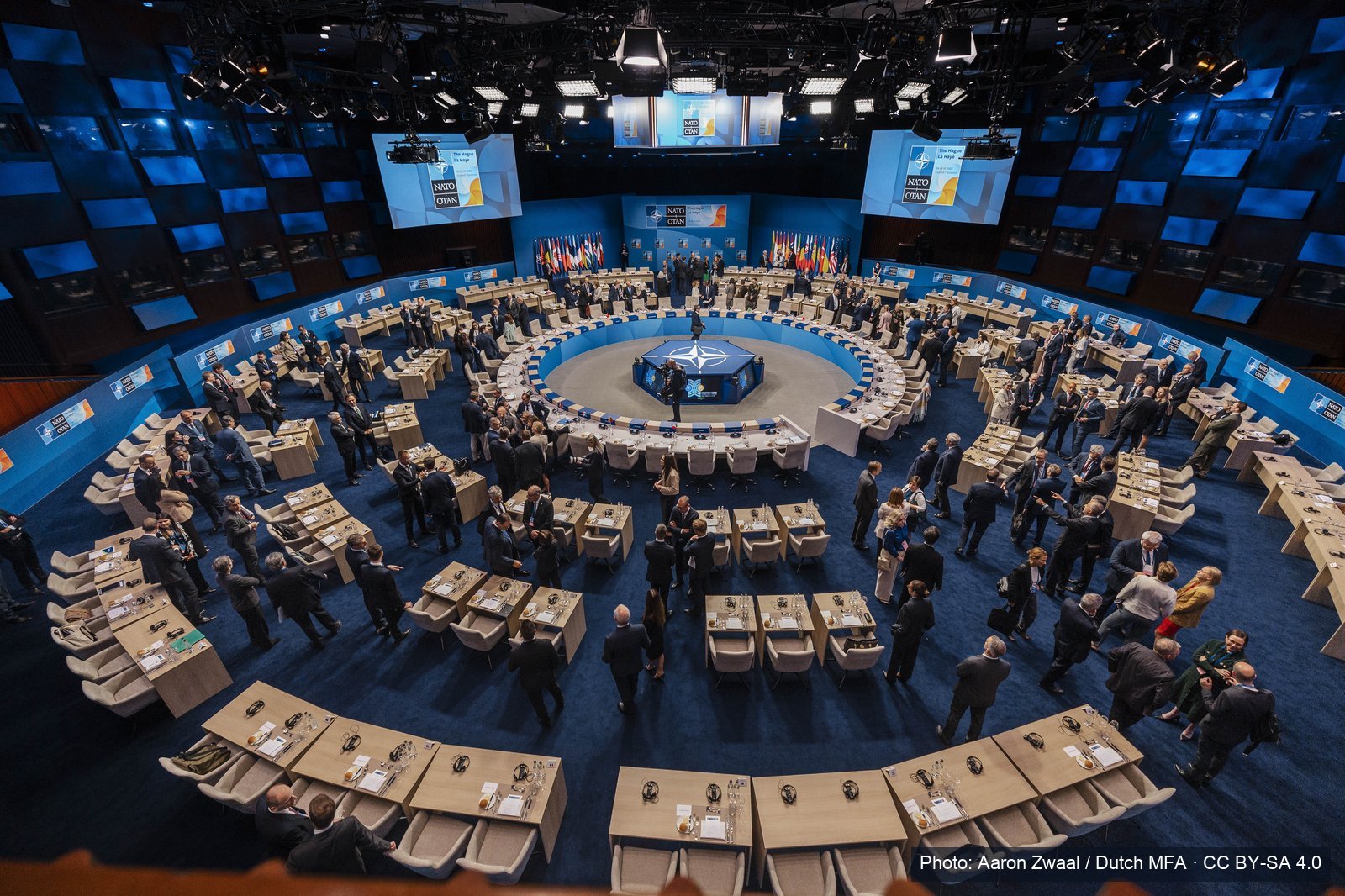 Delegations gather around the plenary table at a NATO summit